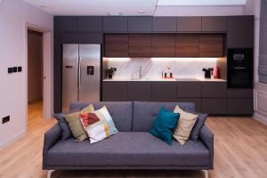 salon z niebieską kanapą i kuchnią w obiekcie Luxurious stunning 2bedroom apartment w Manchesterze