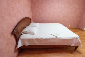 Cama pequeña en habitación con pared de color rosa en вулиця Митницька 55, en Cherkasy