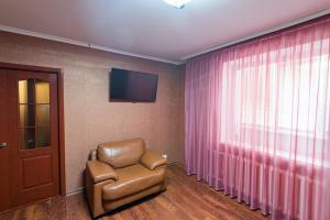 sala de estar con silla y TV en вулиця Митницька 55, en Cherkasy