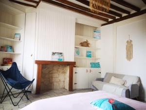 Habitación con cama, sofá y chimenea. en Le Cosy Sénonais, en Sens