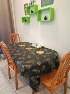 a dining room table with two chairs and a table with a tablecloth at Taman Tunku Miri Budget Homestay in Miri