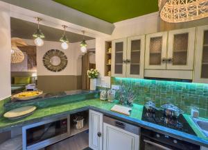 una cocina con encimeras verdes y fregadero en Maison Maria Palmeraie, en Marrakech