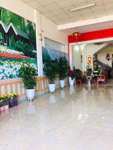 a lobby with potted plants and a mural of flowers at Tien Dat Motel in Pleiku