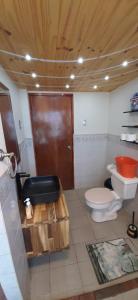 y baño con aseo y lavamanos. en Acogedor apartamento cerca del teleférico amarillo en La Paz