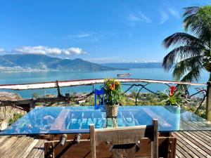 a table on a deck with a view of the water at Lar da Lara in Ilhabela