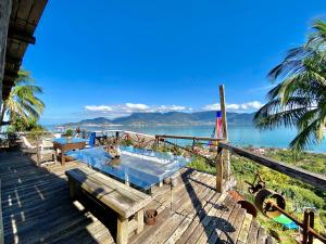 a deck with a hot tub and a view of the water at Lar da Lara in Ilhabela +47 photos