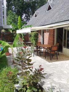 um pátio com uma mesa de madeira e bancos em Grande maison au calme au cœur d un bois em Ferrières