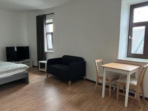 a living room with a black chair and a table at City Appartement B Zur ewigen Lampe dritte Etage in Brühl