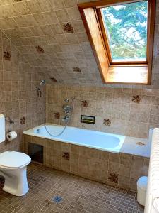a bathroom with a tub and a toilet and a window at Pension zur Heiligen Krone in Mauterndorf