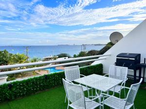 un tavolo e sedie su un balcone con vista sull'oceano di Bel appartement sur l'île de Margarita, avec vue sur la mer a Pampatar