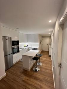 uma cozinha com armários brancos e um balcão branco em Apartamento Arousa Mar em Vilanova de Arousa