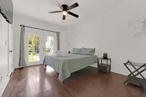 a white bedroom with a bed and a ceiling fan at Heart of West Palm Beach in West Palm Beach