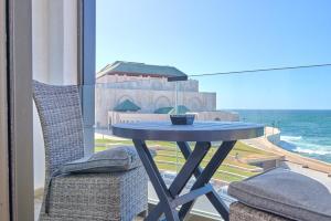 einen Tisch und Stühle auf einem Balkon mit Meerblick in der Unterkunft Apartment Sea View B23 - Mosquée Hassan II - By TheCasaEdition in Casablanca