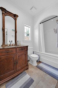 a bathroom with a toilet and a sink and a mirror at Heart of West Palm Beach in West Palm Beach