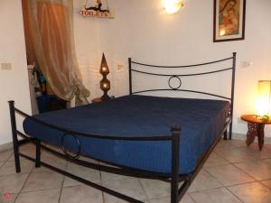 a bedroom with a bed with a blue comforter at Casa Marciana 2 - Isola D'Elba in Marciana