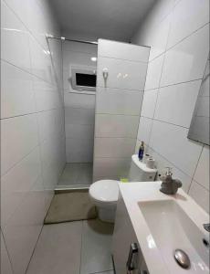 a white bathroom with a toilet and a sink at Cozy room next to el prat airport in El Prat de Llobregat