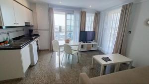 a kitchen and living room with a table and a television at Apartamentos Sol Mar in Los Cristianos