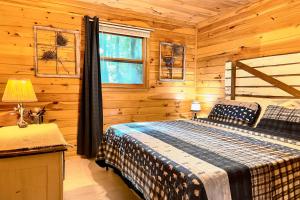 ein Schlafzimmer mit einem Bett in einem Blockhaus in der Unterkunft Coffee Creek Cabin in Sautee Nacoochee