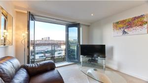 a living room with a couch and a flat screen tv at City Quadrant - Properties Unique in Newcastle upon Tyne