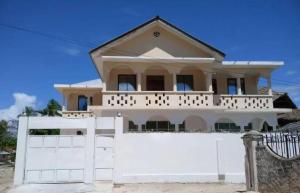 a house with a white fence in front of it at Mauwa House in Paje