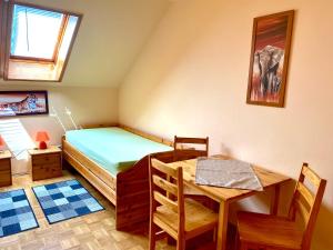 a small bedroom with a bed and a table and chairs at Pension zur Heiligen Krone in Mauterndorf