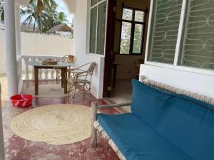 a living room with a blue couch and a table at Mauwa House in Paje