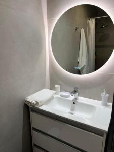 a bathroom with a white sink and a mirror at Ô LAGON in Saint-Gilles les Bains
