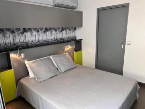 a bedroom with a large bed with white sheets at Ô LAGON in Saint-Gilles les Bains