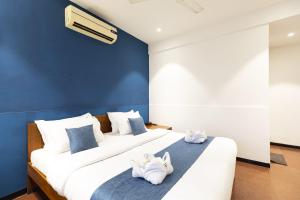 a bedroom with a large bed with towels on it at Hotel Q Deck Rooms - Vile Parle Station and Near to Mumbai Airport in Mumbai