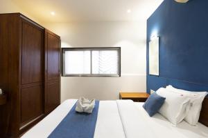a bedroom with a large bed with a blue wall at Hotel Q Deck Rooms - Vile Parle Station and Near to Mumbai Airport in Mumbai