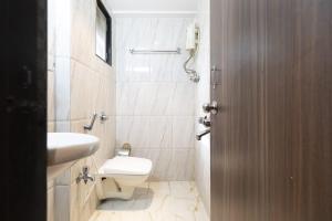 a bathroom with a toilet and a sink at Hotel Q Deck Rooms - Vile Parle Station and Near to Mumbai Airport in Mumbai +23 photos