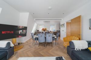 - un salon et une salle à manger avec une table et des chaises dans l'établissement Marble Arch Penthouse 3 Bed, à Londres