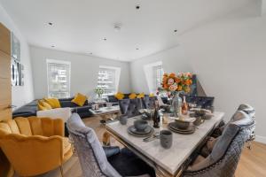a living room with a table and some chairs at Marble Arch Penthouse 3 Bed in London
