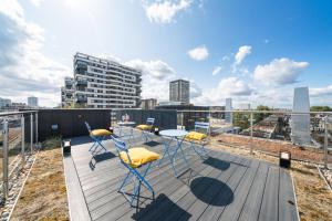 a deck with chairs and a table on top of a building at Marble Arch Penthouse 3 Bed in London