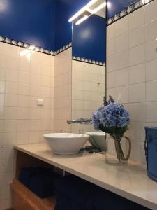 ein Badezimmer mit einem Waschbecken und einer Vase aus Blumen in der Unterkunft SM2 Romantic HOME by the gardens PR Real & Bairro Alto in Lissabon