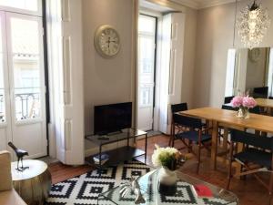 ein Wohnzimmer mit einem Tisch und einer Uhr an der Wand in der Unterkunft SM2 Romantic HOME by the gardens PR Real & Bairro Alto in Lissabon
