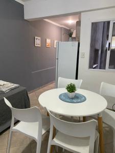 a dining room with a white table and white chairs at FA Temporarios 3 - centro con garage in Corrientes