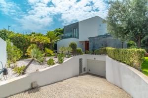 une maison blanche avec un garage blanc dans l'établissement Star Villa with private heated pool in funchal, à Funchal
