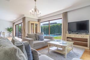 a living room with a couch and a tv at Star Villa with private heated pool in funchal in Funchal