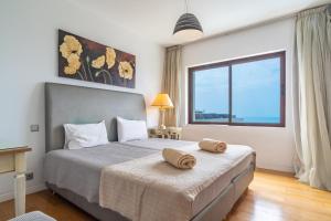 a bedroom with a large bed with a large window at Star Villa with private heated pool in funchal in Funchal