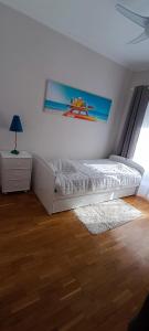 a bedroom with a bed and a painting on the wall at Casa de Praia da Zezinha in Costa da Caparica