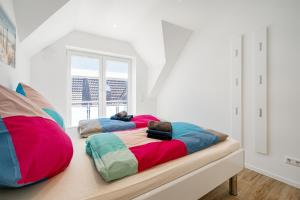 ノルトダイヒにあるNorderneyの白い壁の客室内のベッド2台