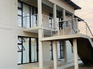 a house with a balcony and a staircase at GoldenWays Apartments in Mbabane