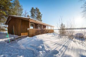 a log cabin in the snow with a lot of snow at Sandsjögården Holiday Resort in Blattniksele +17 photos