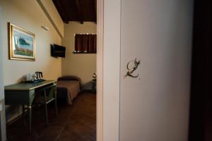 Habitación con puerta y habitación con escritorio. en Albergo La Meridiana, en Castelnuovo del Garda