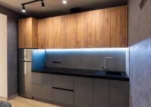 a kitchen with a stainless steel refrigerator and wooden cabinets at Байди Вишневецького 68 in Cherkasy