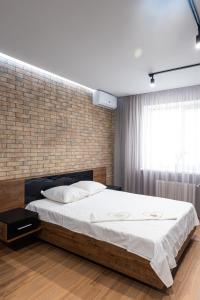 切爾卡瑟的住宿－Байди Вишневецького 68，一间卧室设有一张床和砖墙