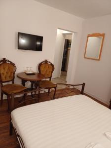 a hotel room with two beds and a table and chairs at Apartament Jurilovca in Jurilovca