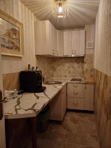 a kitchen with white cabinets and a counter top at Apartament Jurilovca in Jurilovca