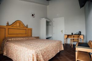 Schlafzimmer mit einem Bett, einem Schreibtisch und einem Tisch in der Unterkunft Albergo La Meridiana in Castelnuovo del Garda